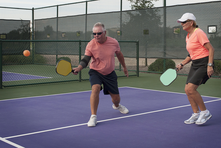 Colorful image of mixed doubles team playing in a pickleball match.