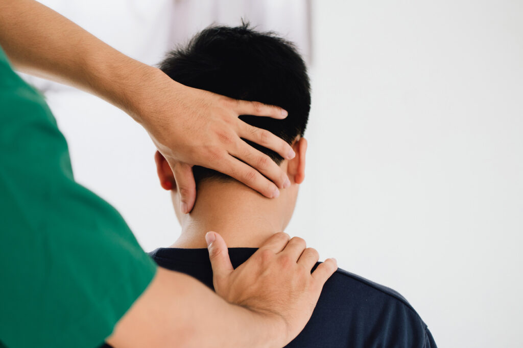 Physical therapist treating a client's neck, addressing headache symptoms