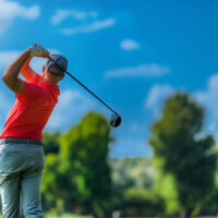 man swinging golf club